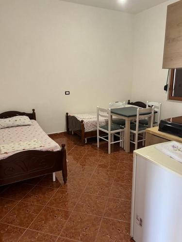 een kamer met 2 bedden en een tafel en stoelen bij Apartament i kendshem in Kavajë