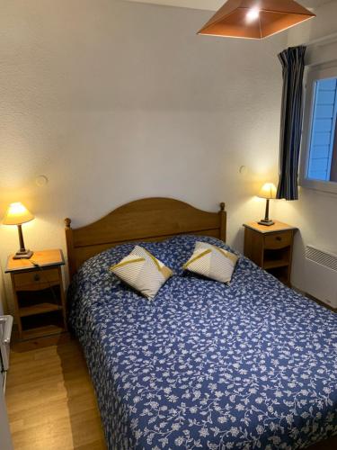 ein Schlafzimmer mit einem Bett mit blauer Decke und 2 Lampen in der Unterkunft Appartement T3 équipé in Carantec