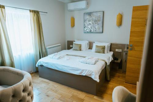 um quarto com uma cama e um sofá em HOTEL Villa Cvijanović - WELLNESS-SPA em Palić