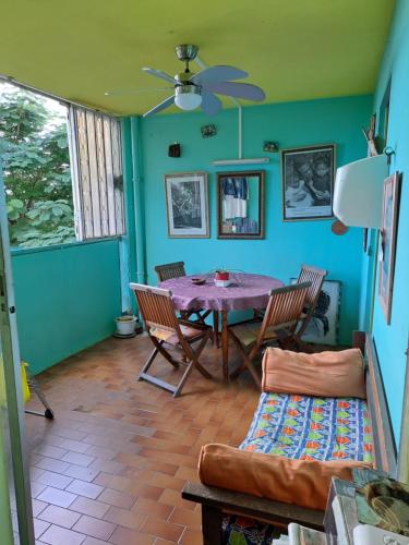 een woonkamer met een tafel en stoelen en een bank bij COLOCATION CITE URBAINE in Pointe-à-Pitre