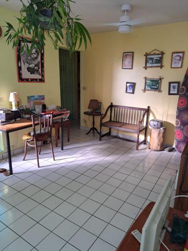 a living room with chairs and a table and a bench at COLOCATION CITE URBAINE in Pointe-à-Pitre
