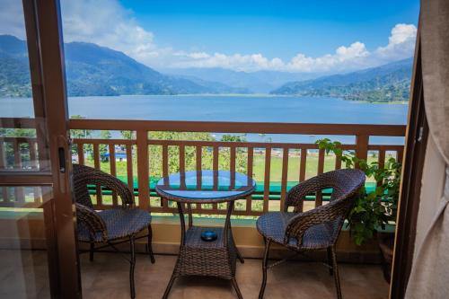 a balcony with a table and chairs and a view at Hotel Fewa Camp in Pokhara