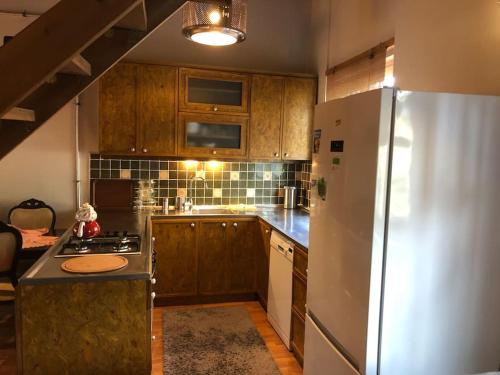 アンタルヤにあるAntalya kaleiçi bahçeli özel muhteşem müstakil villaのキッチン(白い冷蔵庫、木製キャビネット付)