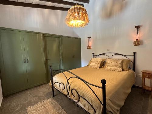een slaapkamer met een bed met groene kasten en een kroonluchter bij Jennas House in Arakapas