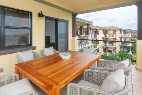 a wooden table and chairs on a balcony at Pineapple Villa 142 condo in Roatan
