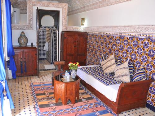 a bedroom with a bed and a table in it at Riad Shaden in Marrakech
