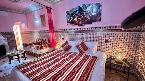 een slaapkamer met een bed en een bank bij Riad Shaden in Marrakesh