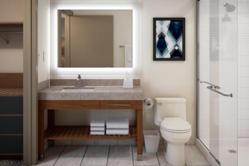 Candlewood Suites Atlanta - Smyrna, an IHG Hotel في أتلانتا: حمام مع حوض ومرحاض ومرآة