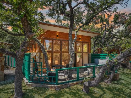 a house with a green fence and trees at Windmill Ranch - Terra Casita #2 in Wimberley
