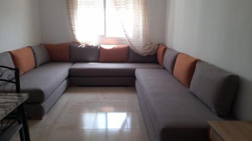 a couch in a living room with a window at Marjane Apartment 1 in Tetouan