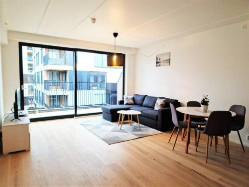 sala de estar con sofá y mesa en Demims Apartments Lillestrøm - Modern & Super Central - 10mins from Oslo S, en Lillestrøm