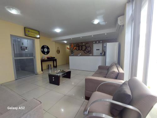 a large living room with couches and a kitchen at Executivo Prime Hotel in Teresina