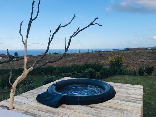 a fire pit sitting on a wooden table next to a tree at Casa da Fonte - Alojamento Local com Jacuzzi in Nordeste