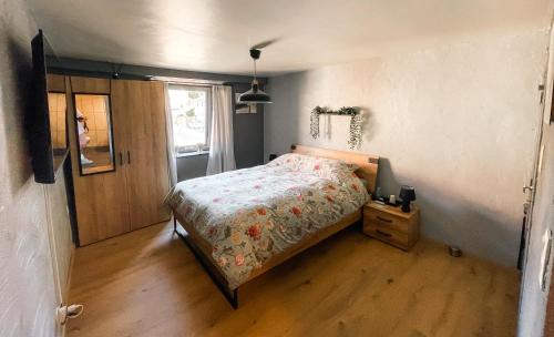 a bedroom with a bed and a wooden floor at Le petit Broux in Aywaille