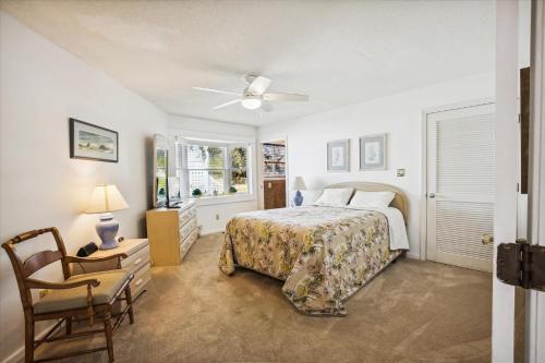 a bedroom with a bed and a chair and a window at 2816 - Tranquil Sound by Resort Realty in Duck