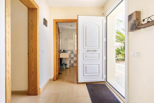 a hallway with a white door and a mirror at Villa Jordi - Cala en Porter in Cala'n Porter