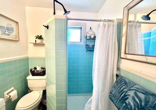 e bagno con servizi igienici e doccia con piastrelle blu. di Cozy 2 Bedroom Apartment Near Local Hotspots a West Palm Beach