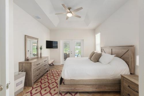 a bedroom with a bed and a ceiling fan at Villa Ilse: New Stylish Home With Private Pool in Inverness