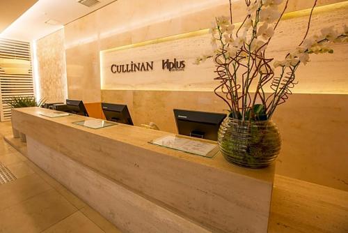 a lobby with a counter with a vase of flowers at CULLINAN DELUXE in Brasília