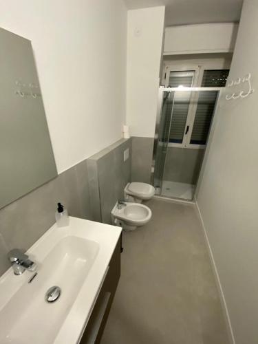 a bathroom with a sink and a toilet and a mirror at San Dionigi 11 Studio Apartments in Milan