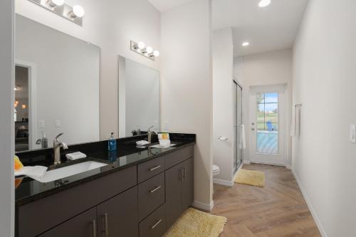 a bathroom with a sink and a large mirror at Villa Ilse: New Stylish Home With Private Pool in Inverness