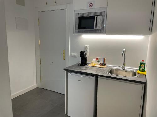 een keuken met een wastafel en een magnetron bij C3 Exclusiva zona Madrid in Madrid