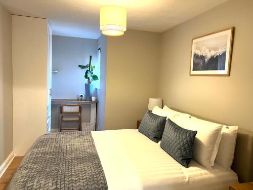 um quarto com uma cama branca com almofadas em Lossie Self-Catering Apartment em Lossiemouth