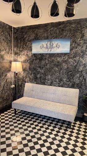 a couch in a room with a checkered floor at คาเฟ่ เดอ แจ่วบอง รูมแอนด์เซอร์วิส in Khon Kaen