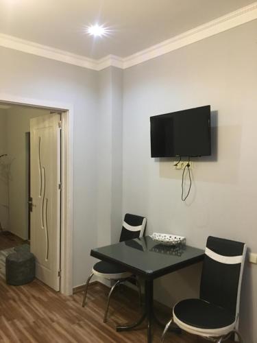 a room with a table and chairs and a tv on the wall at hotel twins G&G in K'obulet'i
