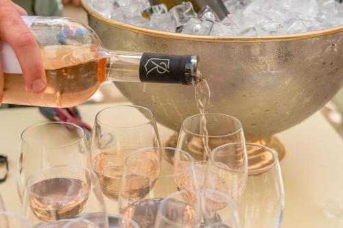 a person pouring wine into glasses in front of a bucket at Le Mas de La Crémaillère in Gréoux-les-Bains