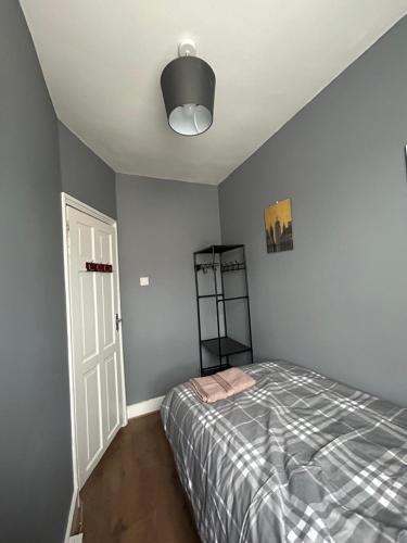 a bedroom with a bed and a white door at Hatton Homes: Tottenham (Thackery Avenue) in London