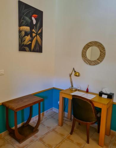 a desk and a table with a bird on the wall at Lyon Faubourg - Saint Priest in Saint-Priest