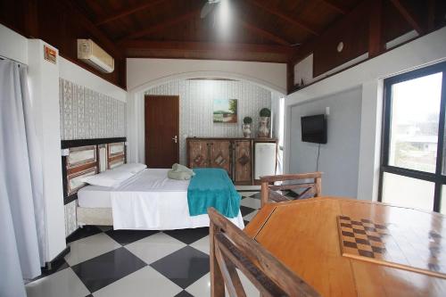 1 dormitorio con 1 cama y 1 mesa en Villa Do Mar en Palhoça