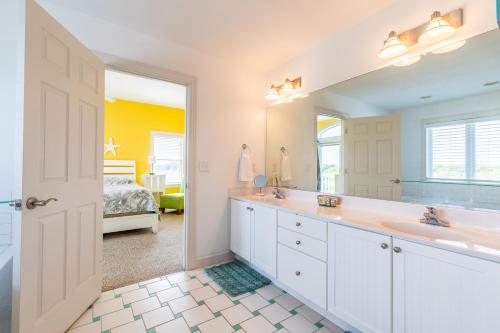 baño con lavabo y espejo grande en 4611 - Prescription OBX, en Southern Shores