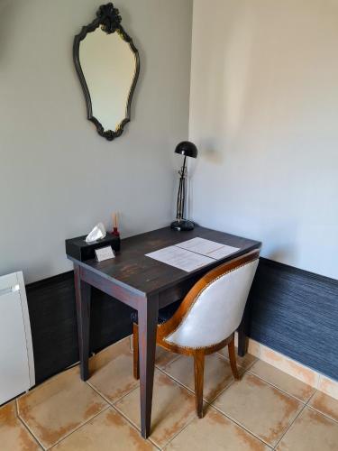a desk with a chair and a mirror on a wall at Lyon Faubourg - Saint Priest in Saint-Priest