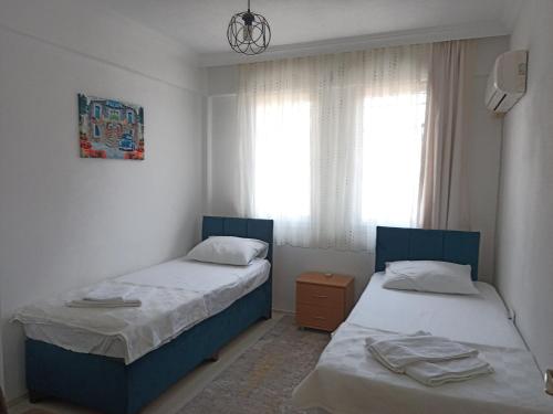 1 dormitorio con 2 camas y ventana en 2 Yatak Odalı Daire-Fethiye, en Fethiye