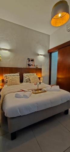 Schlafzimmer mit einem großen Bett mit einem Kopfteil aus Holz in der Unterkunft Chez Nina & Patrick in Douala