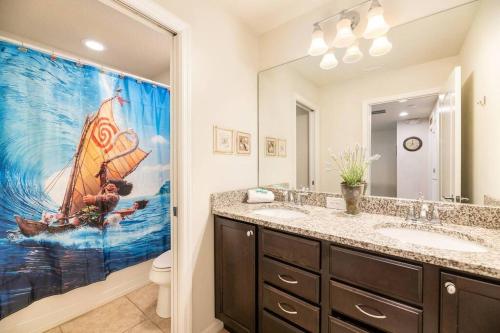 a bathroom with a painting of a sailboat on the shower curtain at The Happy Place! - Upgraded Fun Windsor Home in Kissimmee