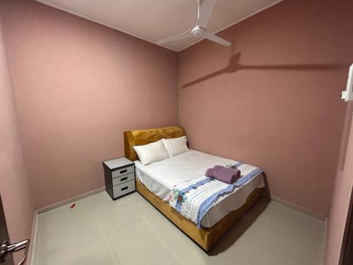 een kleine slaapkamer met een bed en een plafondventilator bij Homestay Taman Hidayah Chawas in Tanah Merah