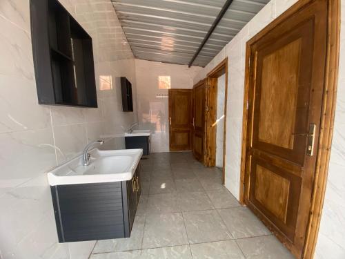 a bathroom with a sink and a mirror and a door at Bedouin Memories Camp in Wadi Rum
