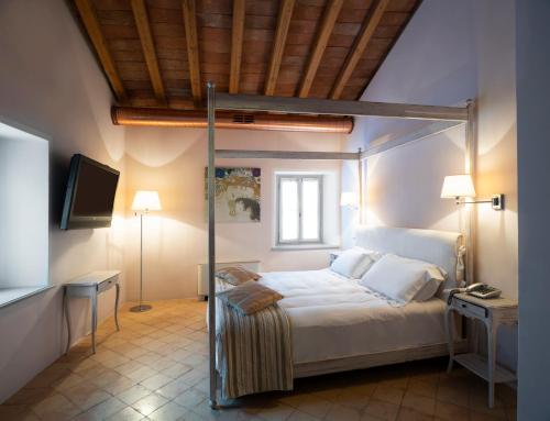 a bedroom with a bed and a television in it at Locanda Cà dei Santi in Induno Olona