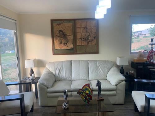 a living room with a white couch and a table at Los Quillayes in Melipilla