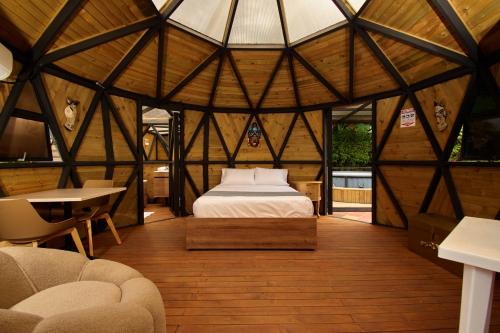 a bedroom in a yurt with a bed and a table at HOTEL KOKUMI in Rionegro