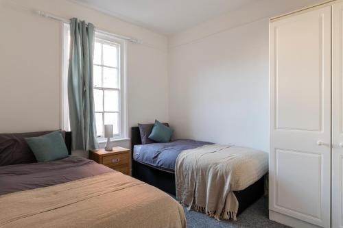 a bedroom with two beds and a window at Quality Stay Room in Brighton & Hove