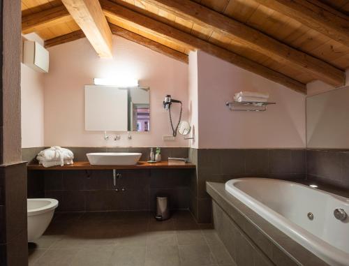 a bathroom with a tub and a toilet and a sink at Locanda Cà dei Santi in Induno Olona