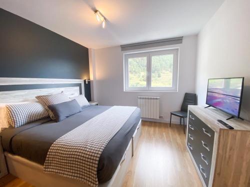 a bedroom with a bed and a flat screen tv at Terraza con Increibles Vistas Para 8 personas - 3 habitaciones - 2 baños - ARINSAL - FREE PARKING in Arinsal