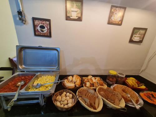 une table recouverte de beaucoup de différents types de nourriture dans l'établissement Pousada Mãe Padroeira, à Aparecida