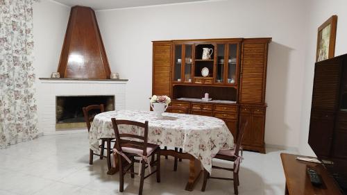 a dining room with a table and chairs and a fireplace at La Casa di Bonaria in Sestu