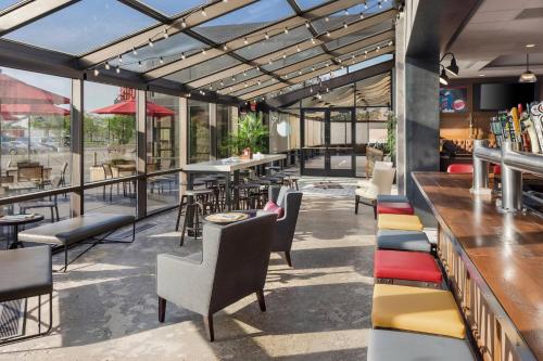 a restaurant with tables and chairs and a bar at Delta Hotels by Marriott Minneapolis Northeast in Minneapolis