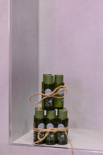 a group of four green bottles in a box at hotelise l illusion Apartment in Yerevan